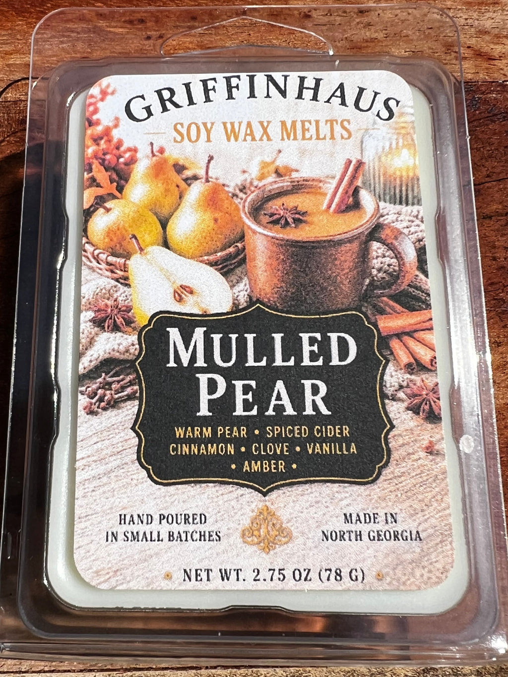 Griffinhaus Mulled Pear soy wax melts in a clear plastic clamshell package, placed on a wooden surface.