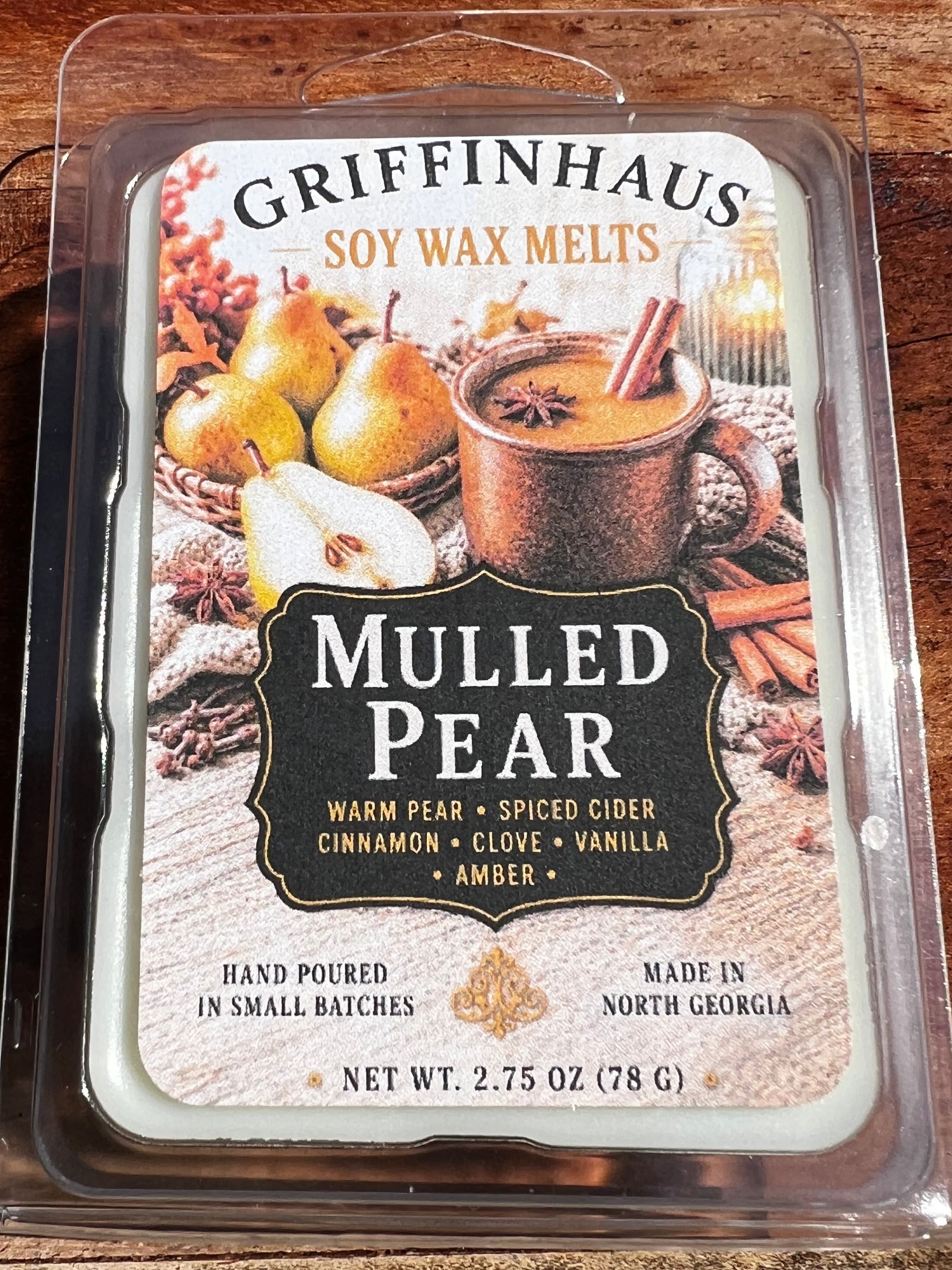 Griffinhaus Mulled Pear soy wax melts in a clear plastic clamshell package, placed on a wooden surface.