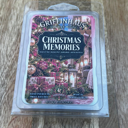 Griffinhaus Scents 'Christmas Memories' sand poured wax melt in a clear plastic clamshell package, placed on a wooden cutting board.